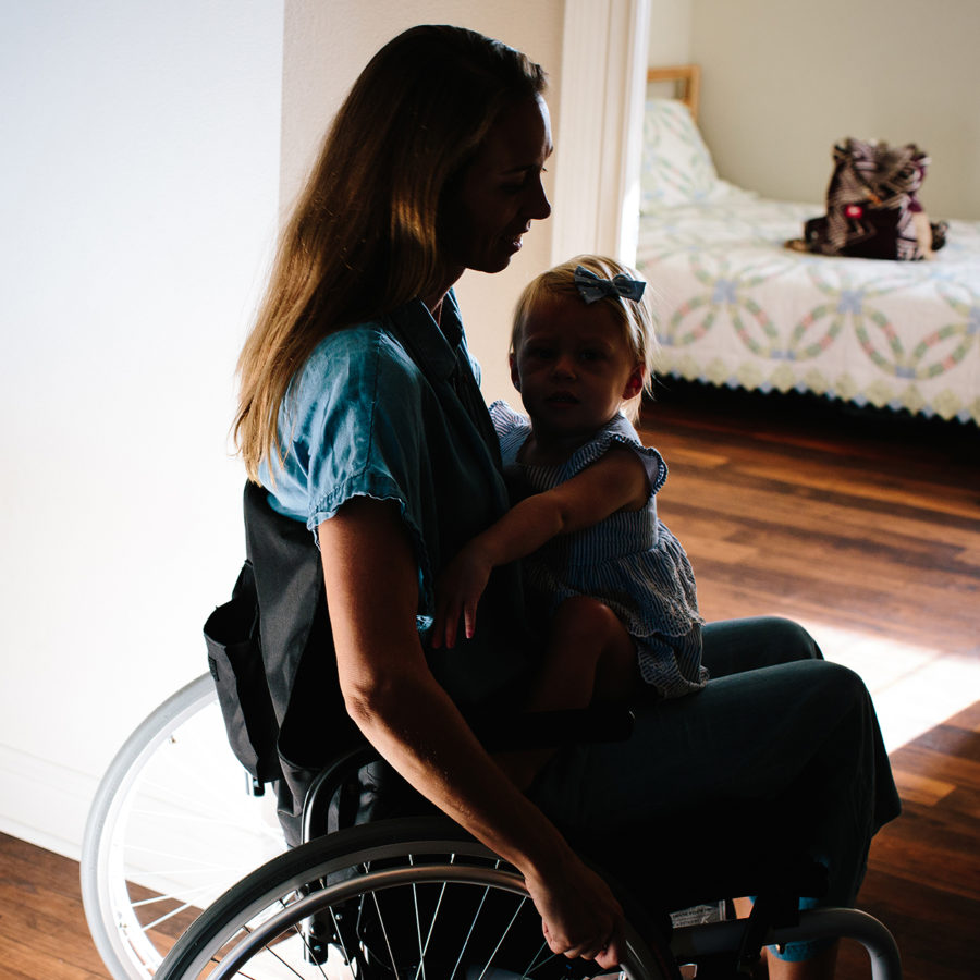 Sharon sitting in a wheelchair with her daughter on her lap.